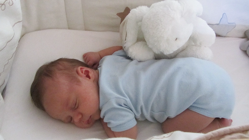 Bébé dort paisiblement en body bleu