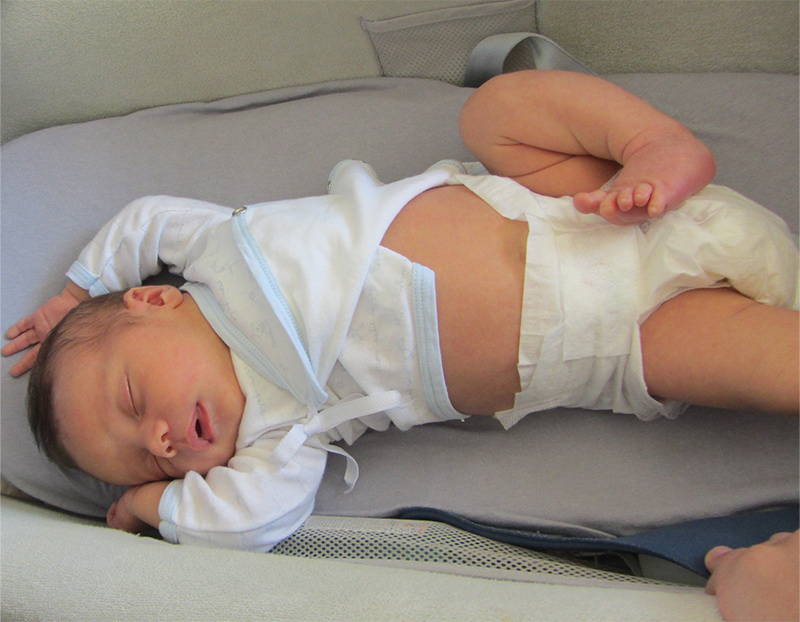 Bébé qui dort dans un pyjama d'été avec un pied relevé