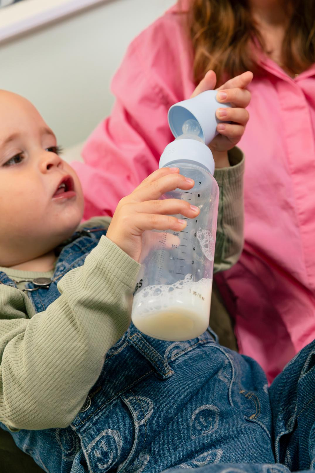 Un bébé qui ouvre son biberon